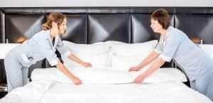 2 housekeepers making a bed in hotel