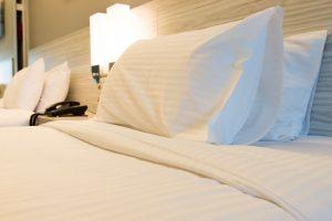 Close up of hotel bed with satin striped linen